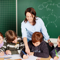 Bei kommunalen Schulen tragen die kommunalen Körperschaften den Personalaufwand und den Schulaufwand. Lehrerin mit Schülern