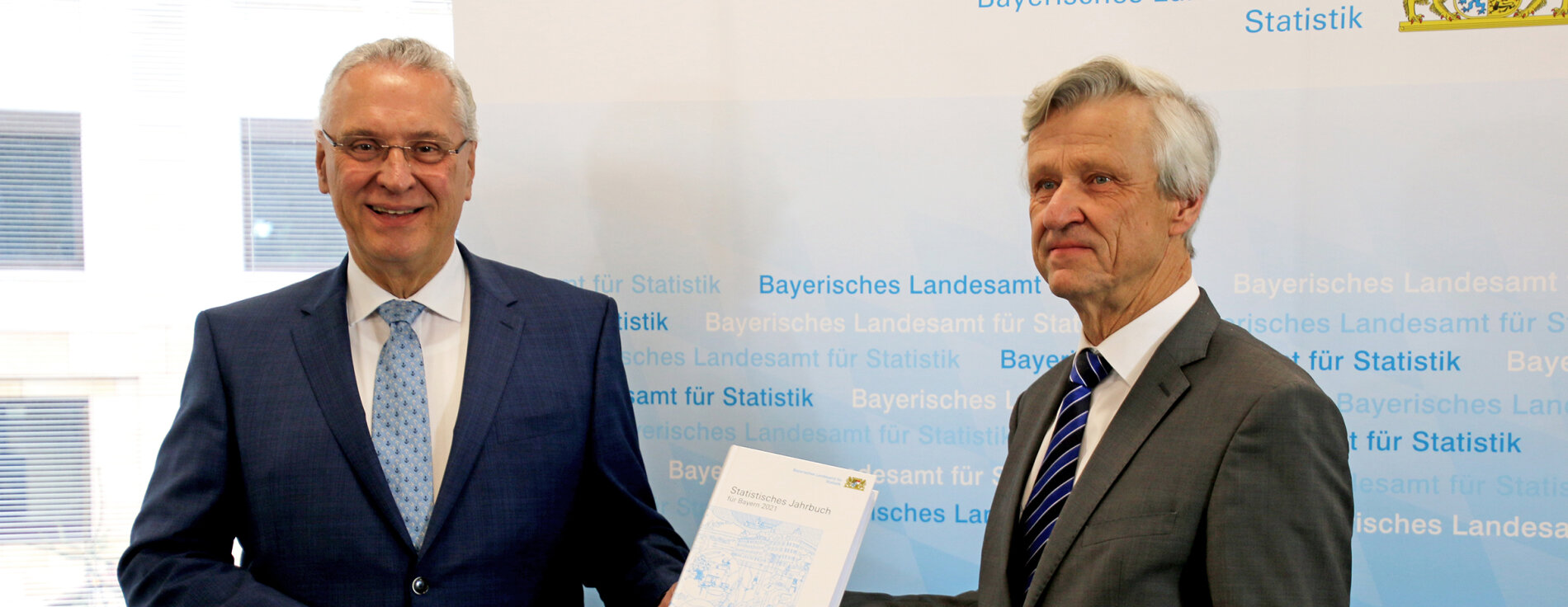 16. Dezember 2021: Positive Nachrichten verkündet Innenminister Joachim Herrmann bei der Vorstellung des Statistischen Jahrbuchs für 2021: „Die 2020 von der Pandemie stark gebeutelte Wirtschaft und der Arbeitsmarkt sind in Bayern ganz klar auf Erholungskurs. Bayern wächst weiter und bleibt attraktiver Lebensmittelpunkt.“ Innenminister Joachim Herrmann mit statistischem Jahrbuch in der Hand und Präsident des Landesamtes für Statistik Dr. Thomas Gößl