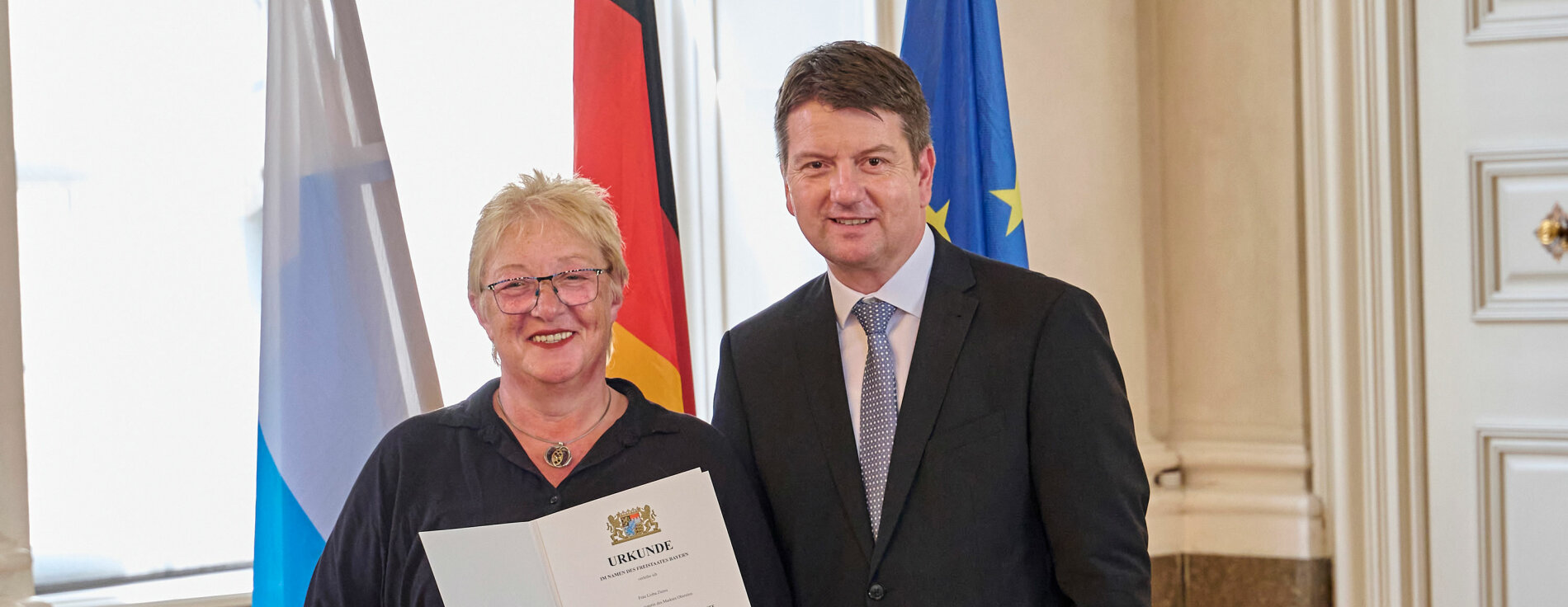11. Juli 2024: Innen- und Kommunalstaatssekretär Sandro Kirchner hat in Würzburg 14 Kommunale Verdienstmedaillen in Silber und Bronze an langjährige kommunale Mandatsträgerinnen und Mandatsträger verliehen. Im Bild mit Lioba Zieres, Erste Bürgermeisterin des Marktes Obersinn. Sandro Kirchner und Lioba Zieres mit Urkunde