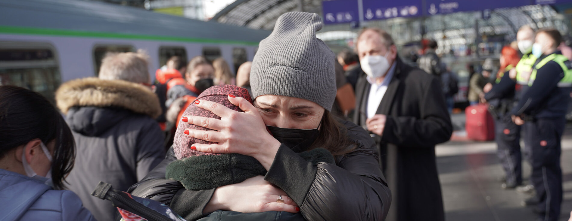 Ankunft ukrainischer Flüchtlinge in Deutschland Menschen am Bahnsteig, im Vordergrund zwei sich umarmende Frauen