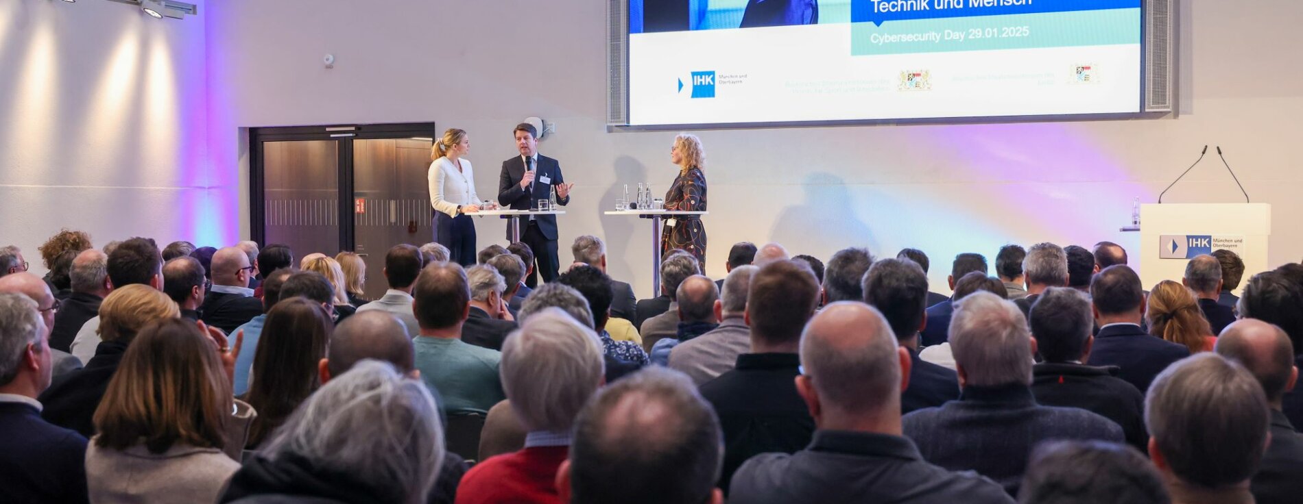 29. Januar 2025: Cyberkriminalität hat sich zu einer der größten Gefahren für Unternehmen entwickelt. Bayern will insbesondere kleinere und mittlere Unternehmen dabei unterstützen, sich bestmöglich vor Cyberangriffen zu schützen und vorbereitet zu sein. Innenstaatssekretär Sandro Kirchner betonte: „Unzureichende Sicherheitsvorkehrungen können fatale Folgen haben. Ein wirksamer Schutz gegen Cyberangriffe und eine starke Cyberresilienz in Unternehmen müssen für Entscheidungsträger deshalb oberste Priorität haben." Auf dem Bild ist ein Gesamtblick in den Veranstaltungssaal mit den Gästen zu sehen, die der Talkrunde mit Innenstaatssekretär Sandro Kirchner lauschen.