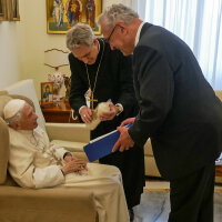 „Allerbeste Glückwünsche aus der Bayerischen Heimat“: Papst em. Benedikt XVI., Erzbischof Georg Gänswein und Innenminister Joachim Herrmann bei der Übergabe einer Wallfahrtskerze mit der Schwarzen Madonna aus Altötting. Papst em. Benedikt XVI., Erzbischof Georg Gänswein und Innenminister Joachim Herrmann