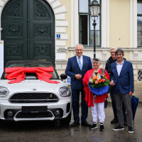 Eine große Freude war es für den Innenminister, den Hauptpreis des Verkehrssicherheitsgewinnspiels 2021 an den Gewinner aus Nordrhein-Westfalen zu übergeben. Innenminister Joachim Herrmann mit Gewinnern neben BMW Mini mit Schleife