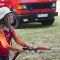 Mädchen mit Feuerwehrschlauch Mädchen mit Feuerwehrschlauch