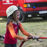 Mädchen mit Feuerwehrschlauch Mädchen mit Feuerwehrschlauch